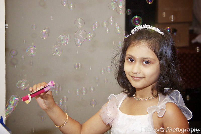 Young girl playing with a bubble machine at birthday party - party photography sydney